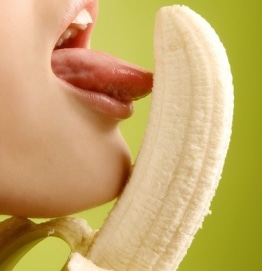 Mulher sexy lambe uma banana simulando um boquete